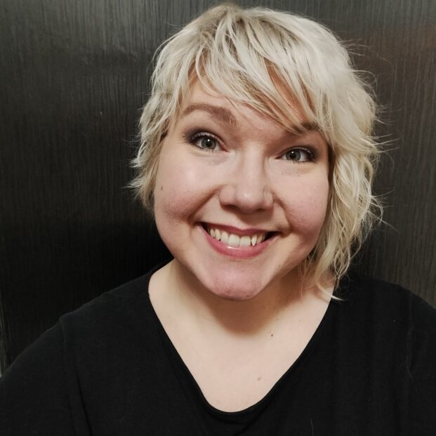 Kasvokuva Venlasta. Hän hymyilee kohtisuoraan kameraan ja hänellä on lyhyet vaaleat hiukset.