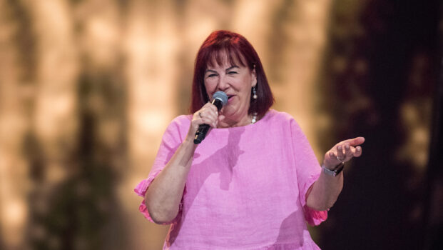 Ewa laulaa mikrofoniin pinkki asussa.