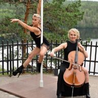 Tankoleidit suomalaisessa kulttuurimaisemassa, Hämeenlinnan Aulangon näköalatasanteella. Elina soittaa selloa, Tintti tanssii tangolla. Taustalla uljas mänty, näköalatasanteen kaunis musta metallikaide ja järvi, jonka takana siintää metsää.