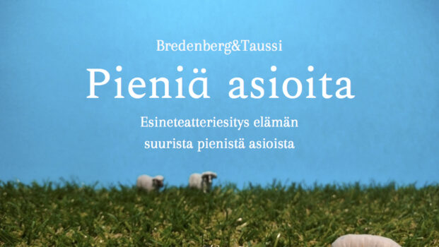 Pieniä asioita teatteriesityksen teoskuva, jossa on näyttämöasetelma: kolme lammasfiguuria keinonurmella taivaansinistä taustaa vasten
